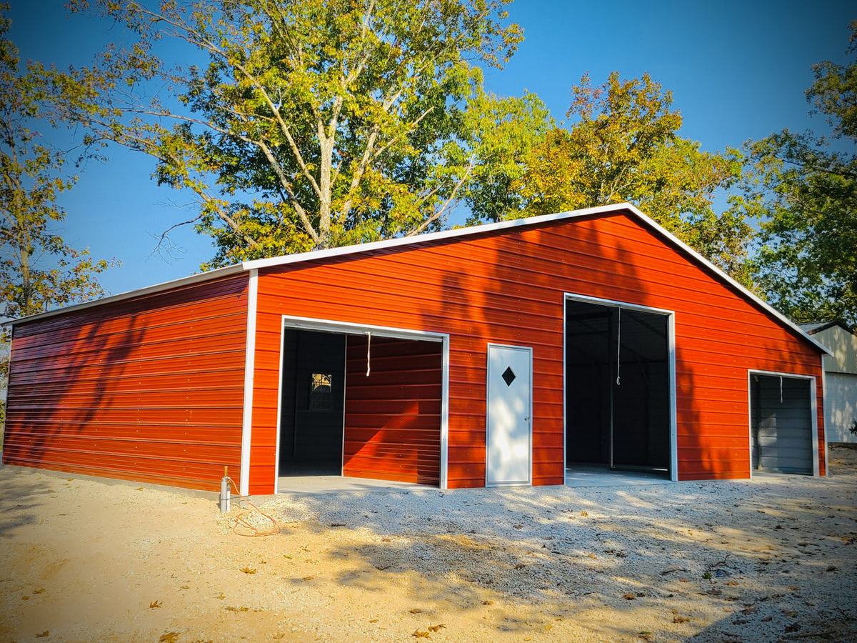 Enclosed red Legacy metal barn with roll-up and walk-in doors